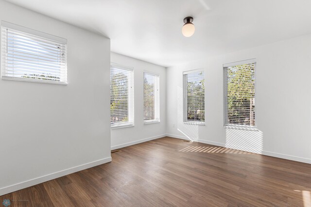 empty room with dark hardwood / wood-style flooring