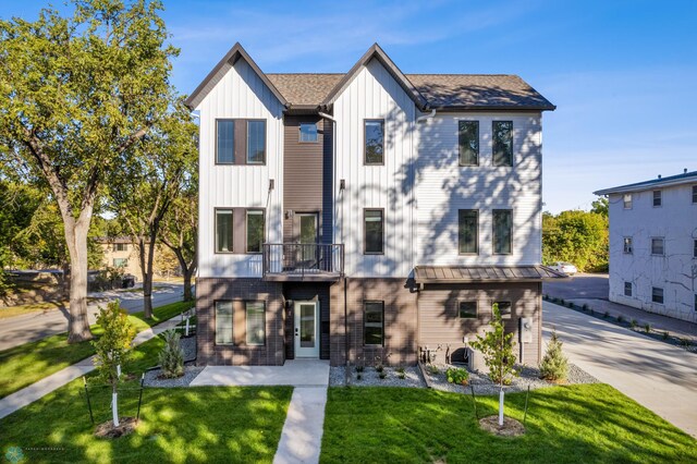 rear view of property with a balcony and a yard