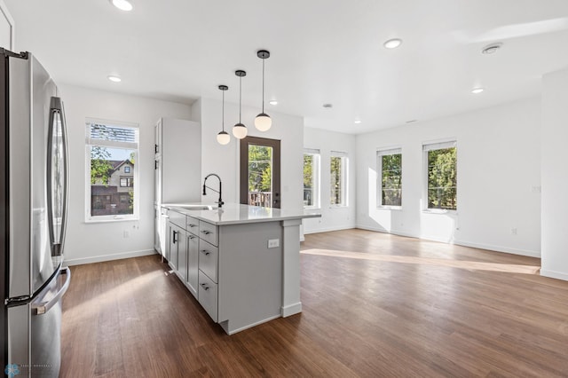kitchen with a sink, plenty of natural light, freestanding refrigerator, and dark wood-style flooring