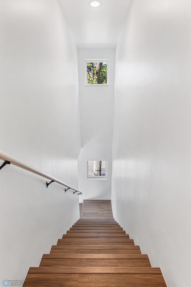 staircase with recessed lighting and wood finished floors