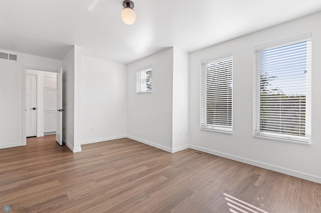 interior space featuring baseboards, visible vents, and light wood finished floors