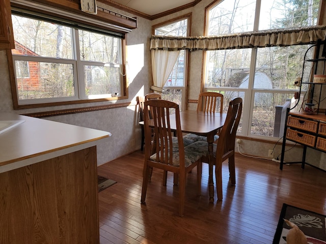 dining space with a healthy amount of sunlight, ornamental molding, and dark hardwood / wood-style floors