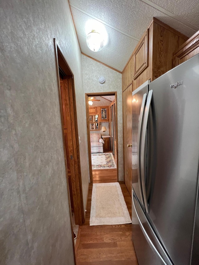 kitchen featuring ceiling fan, dark hardwood / wood-style flooring, stainless steel fridge, and vaulted ceiling