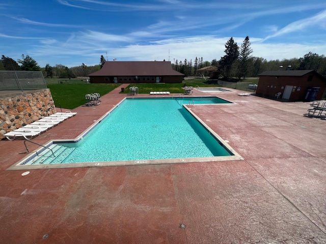 view of swimming pool featuring a yard and a patio area