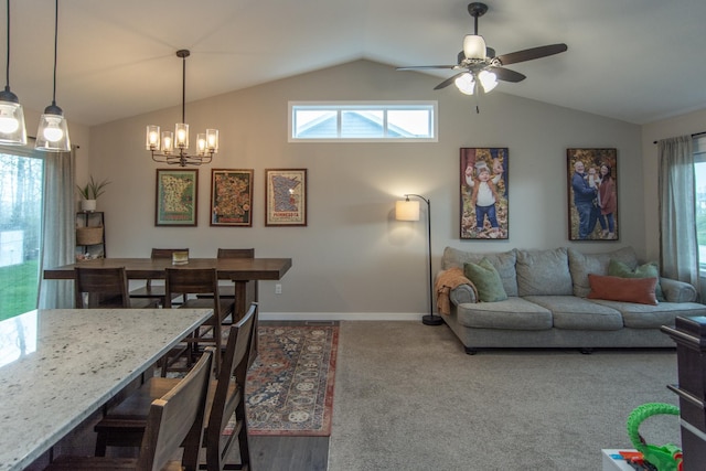 carpeted living area with a healthy amount of sunlight, baseboards, ceiling fan with notable chandelier, and lofted ceiling