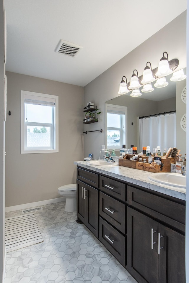 full bath featuring visible vents, plenty of natural light, and a sink