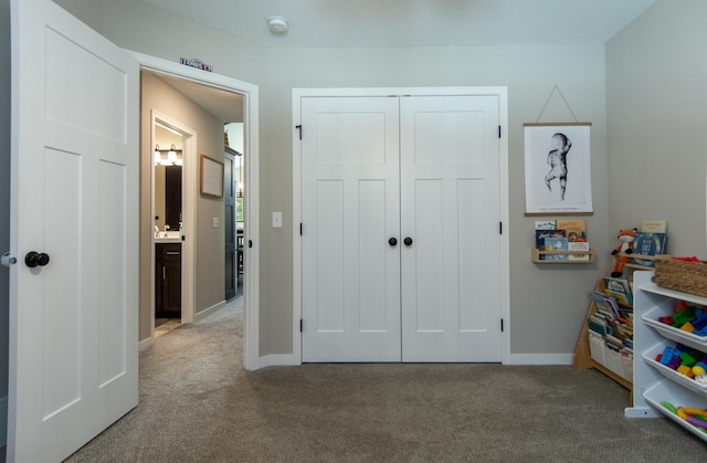 recreation room with baseboards and carpet