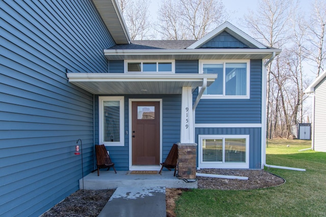 entrance to property featuring a yard and covered porch