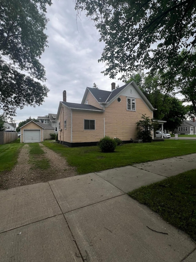 view of side of property with an outdoor structure, a yard, and a garage