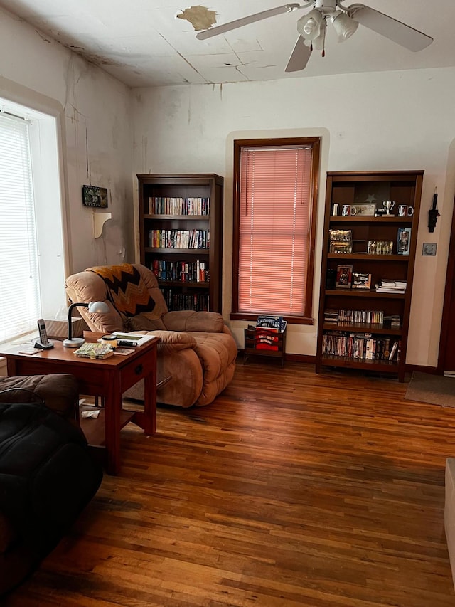 living room featuring ceiling fan and dark hardwood / wood-style flooring