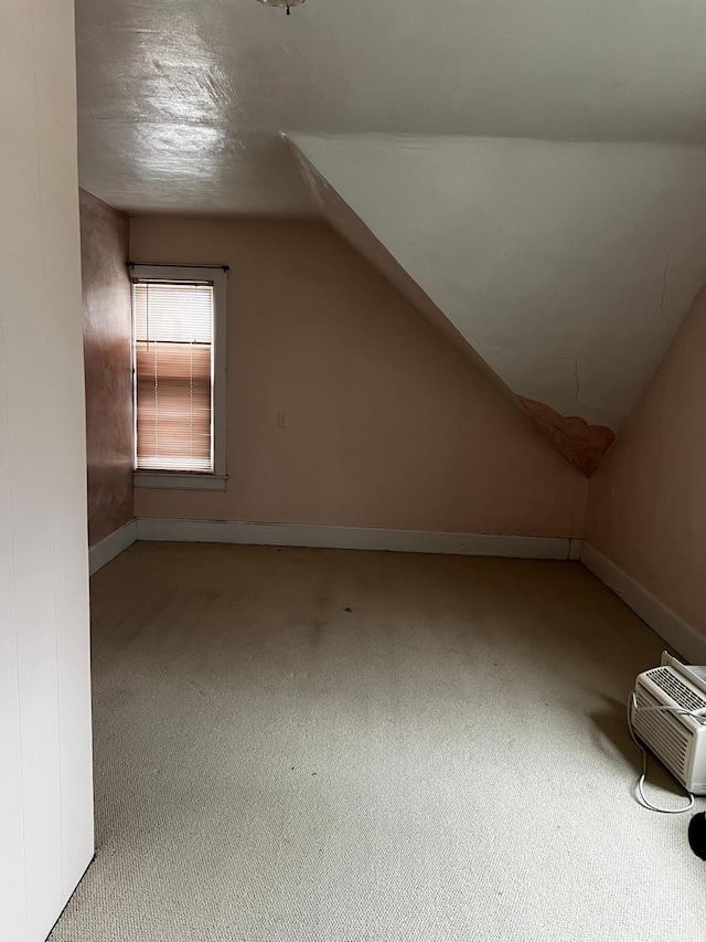 bonus room with a wall mounted air conditioner, carpet floors, and vaulted ceiling