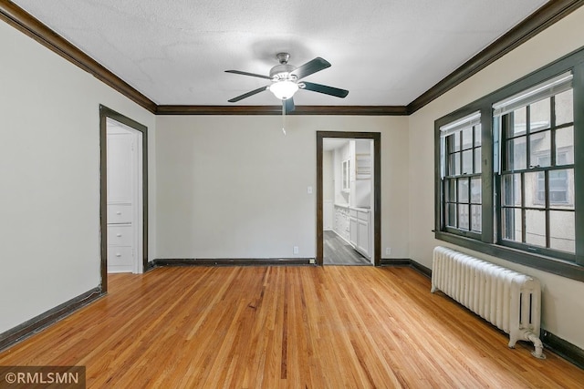 unfurnished room with a textured ceiling, ornamental molding, light hardwood / wood-style flooring, radiator heating unit, and ceiling fan