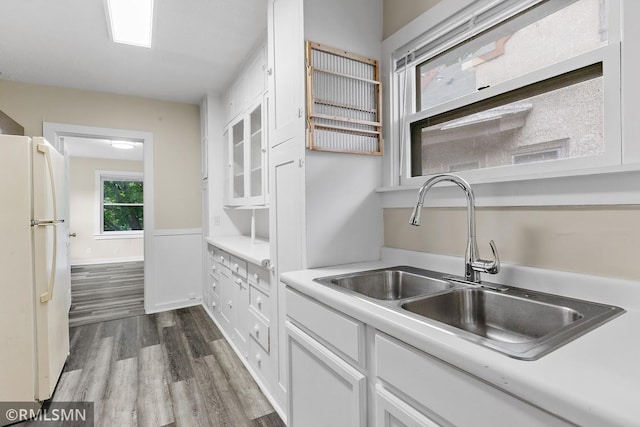 kitchen with hardwood / wood-style flooring, white cabinets, sink, and white refrigerator