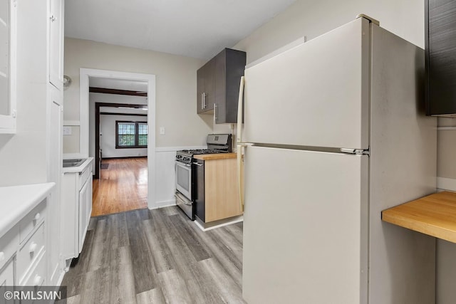 kitchen with white refrigerator, light hardwood / wood-style floors, and gas stove