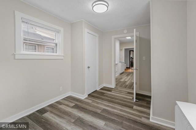 hall featuring a textured ceiling and hardwood / wood-style floors