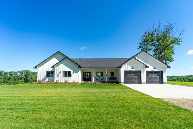 modern inspired farmhouse featuring a front yard and a garage