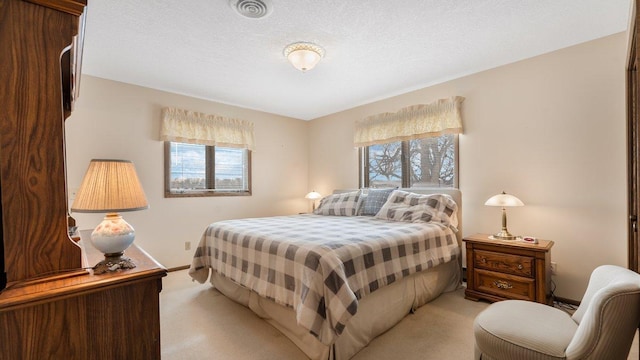 bedroom featuring light carpet and a textured ceiling