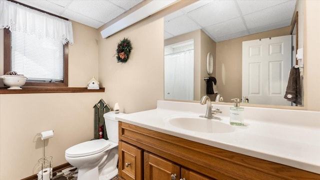 bathroom featuring a paneled ceiling, vanity, and toilet