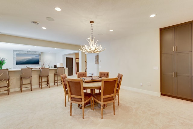 carpeted dining room with a chandelier