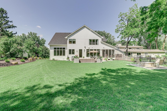 rear view of house featuring outdoor lounge area, a yard, a patio, and a sunroom