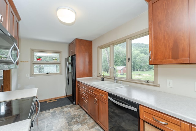 kitchen featuring sink, black dishwasher, range with electric cooktop, stainless steel refrigerator, and light tile patterned floors