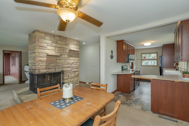 dining area featuring a fireplace, visible vents, dark carpet, stone finish flooring, and baseboards