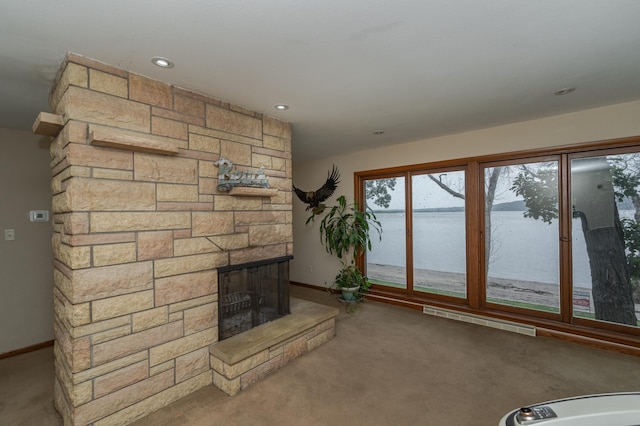 unfurnished living room with baseboards, a fireplace, visible vents, and carpet flooring