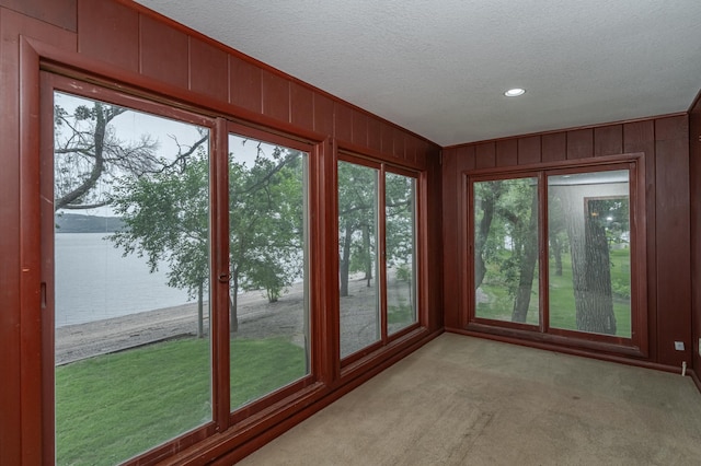 unfurnished sunroom with a water view