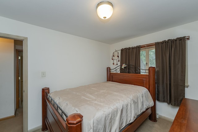 bedroom with light colored carpet and baseboards