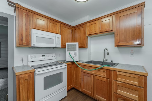 kitchen featuring brown cabinets, white appliances, light countertops, and a sink