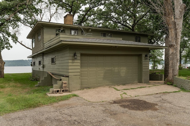 exterior space with roof with shingles, a chimney, and a water view