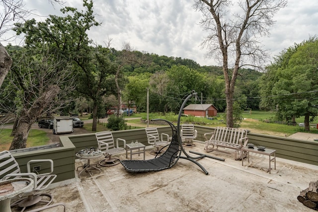 surrounding community with a patio area and a view of trees