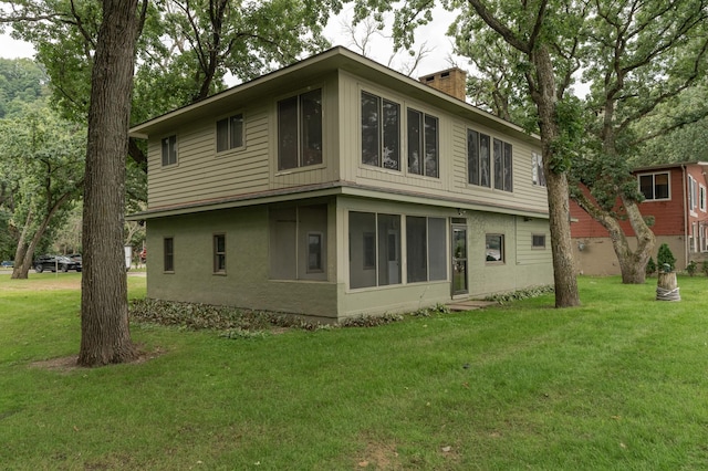 rear view of property featuring a yard and a chimney