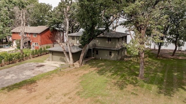 view of front facade with a garage, concrete driveway, and a front lawn