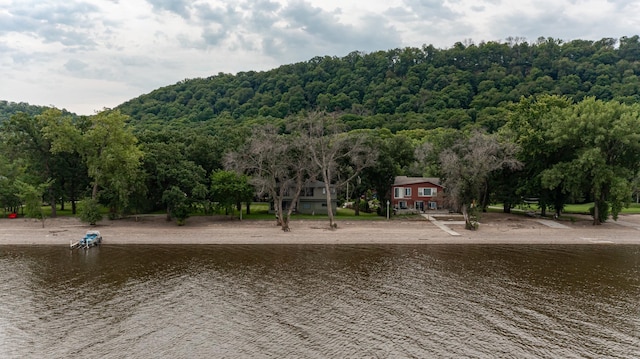 surrounding community with a water view and a view of trees