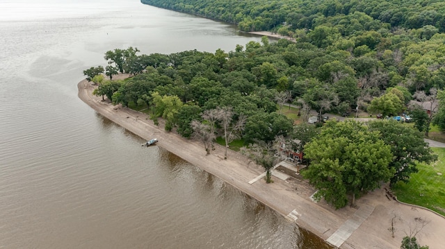 birds eye view of property featuring a water view and a wooded view