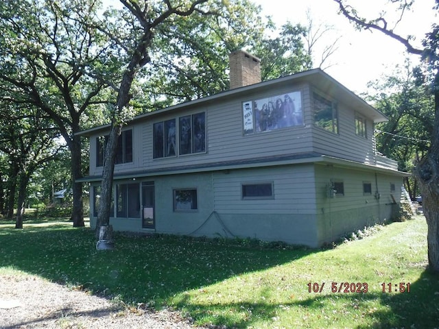 view of property exterior featuring a lawn and a chimney