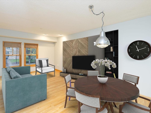 dining space with wood-type flooring and a textured ceiling