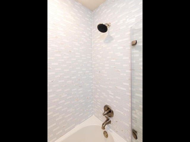 interior details with tiled shower / bath combo