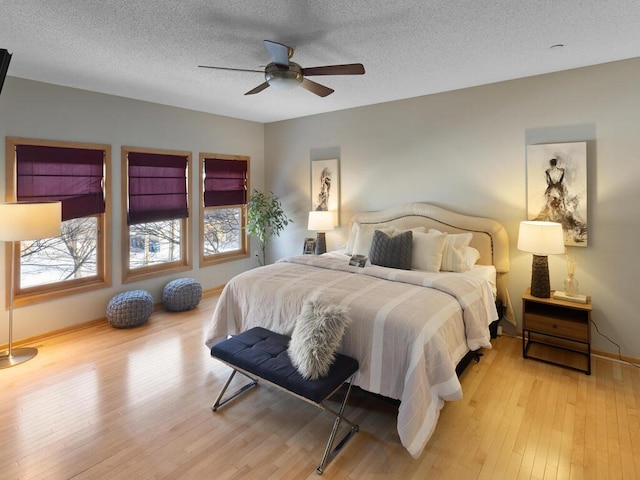 bedroom featuring ceiling fan, light wood-type flooring, and a textured ceiling