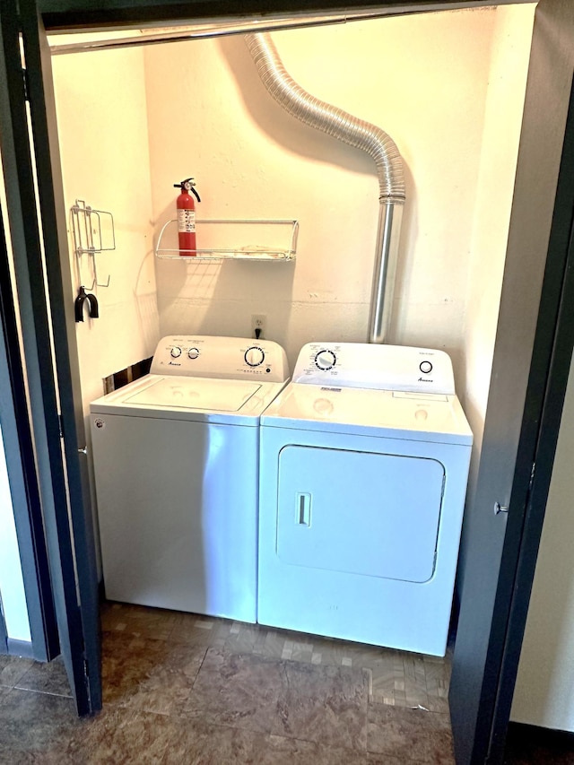 clothes washing area with washing machine and dryer