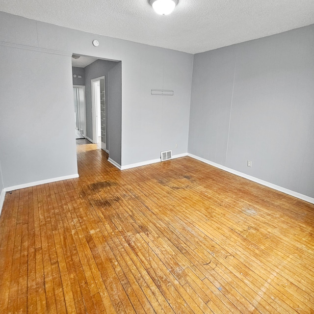 spare room featuring hardwood / wood-style floors and a textured ceiling