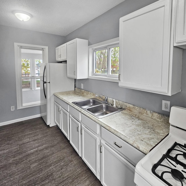 kitchen with a textured ceiling, range, sink, white cabinetry, and dark hardwood / wood-style flooring