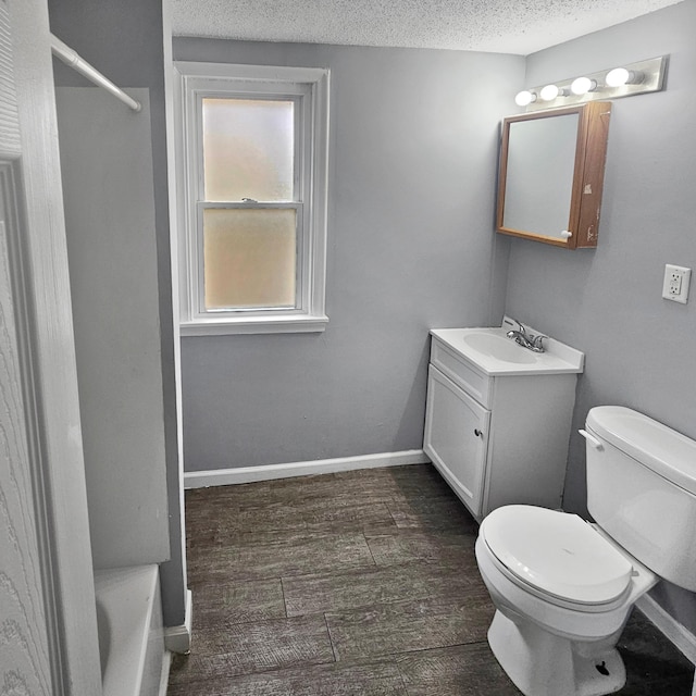 bathroom featuring toilet, oversized vanity, hardwood / wood-style floors, and a textured ceiling