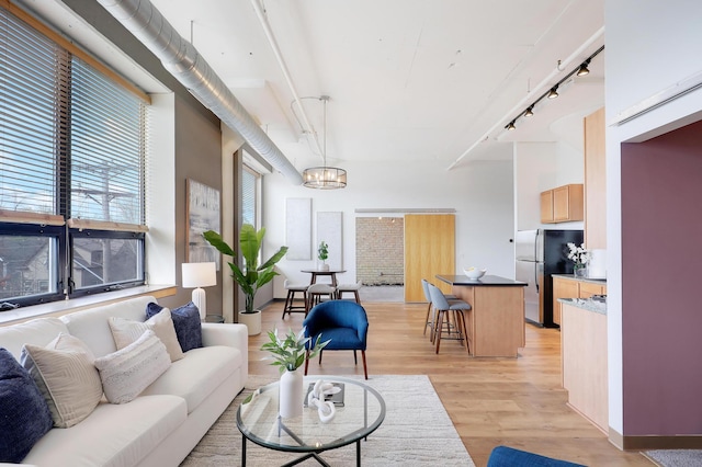 living room with light wood-type flooring and an inviting chandelier