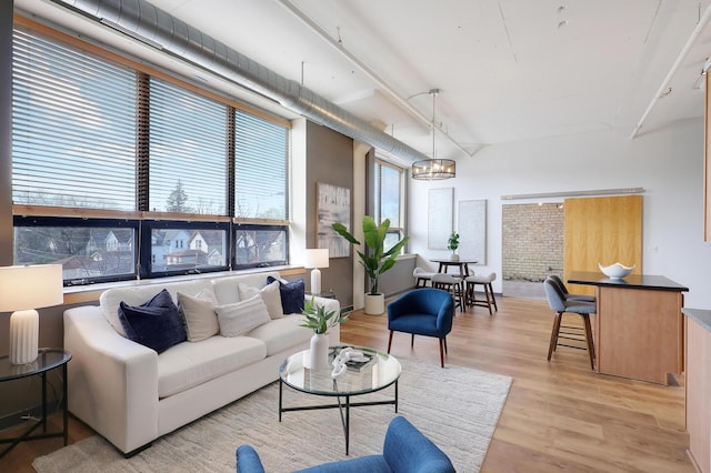 living room with light hardwood / wood-style flooring and a notable chandelier