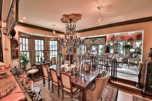 dining space with crown molding, an inviting chandelier, and light wood-type flooring