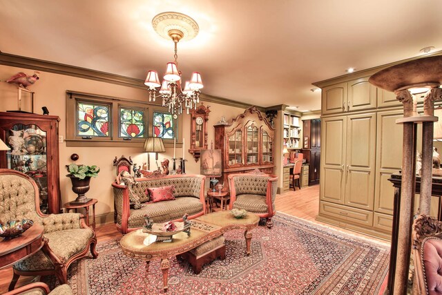 living area with crown molding, an inviting chandelier, and light hardwood / wood-style flooring