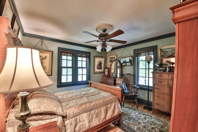 bedroom with ceiling fan, ornamental molding, and hardwood / wood-style floors