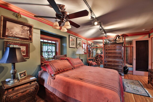 bedroom with hardwood / wood-style floors and ornamental molding